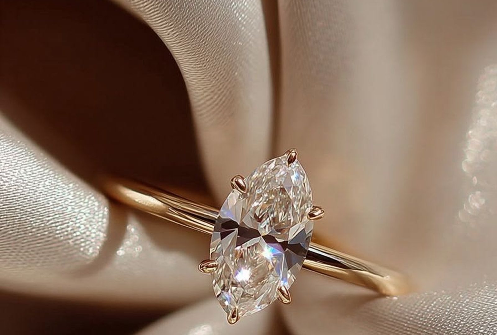 A marquise-cut diamond solitaire on champagne silk